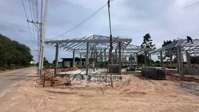 Modern construction site showcasing steel frame structure of a new building under clear skies.
