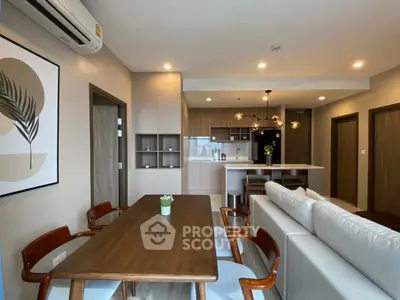 Modern open-plan living room and kitchen with stylish decor and ample natural light.