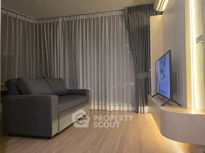Modern living room with sleek sofa and wall-mounted TV, featuring elegant floor-to-ceiling curtains.