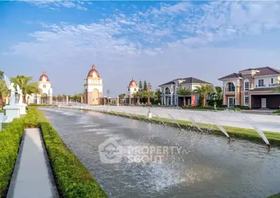 Luxurious estate with stunning fountains and elegant architecture under a clear blue sky.