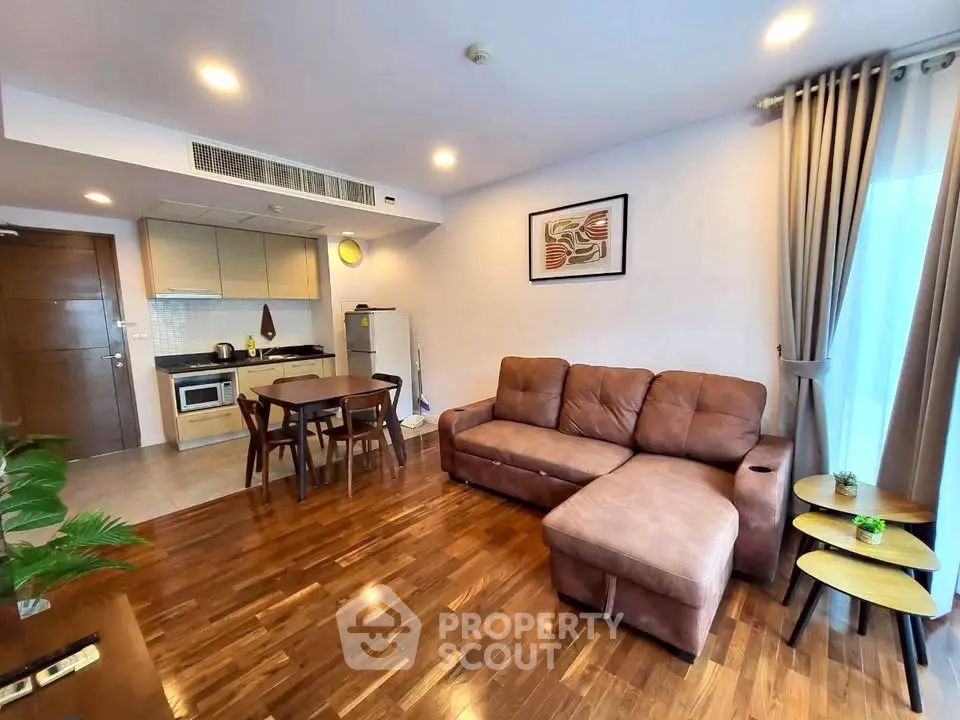 Modern living room with open kitchen, cozy sofa, and stylish decor