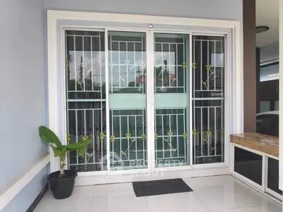 Modern home entrance with sliding glass doors and decorative security bars.