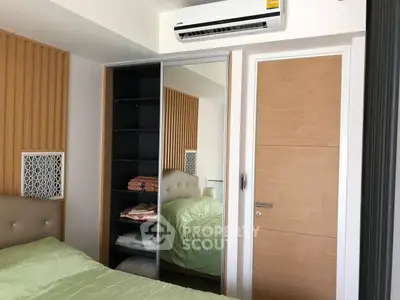 Modern bedroom with mirrored wardrobe and air conditioning unit