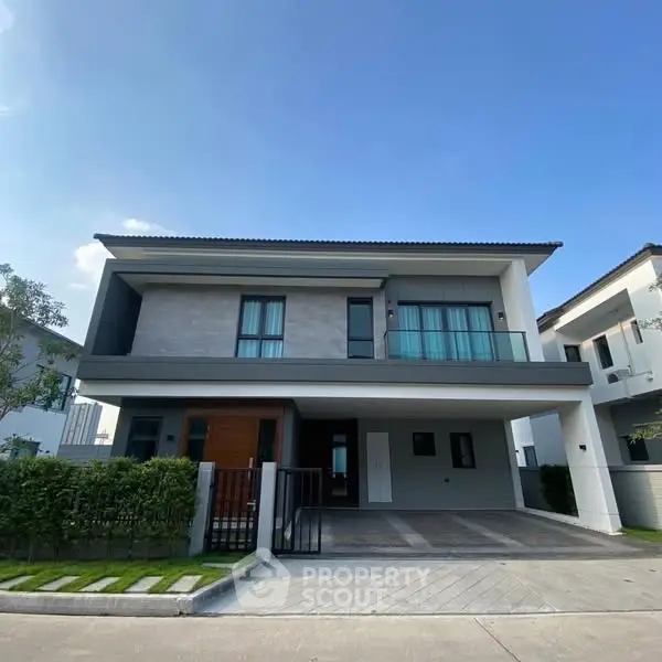 Modern two-story house with sleek design and spacious driveway in a serene neighborhood.