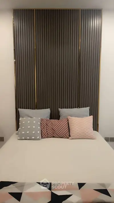 Modern bedroom with stylish pillows and elegant wall paneling