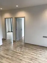 Spacious modern apartment with sleek wooden flooring and open layout.