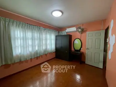 Spacious bedroom with parquet flooring and ample natural light