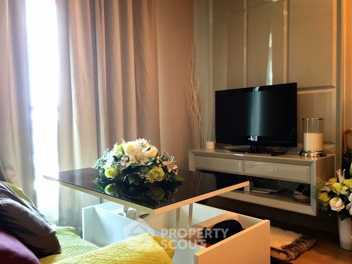 Cozy living room with modern TV stand and elegant floral centerpiece, perfect for relaxation.