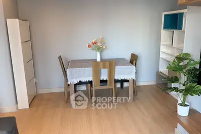 Charming dining area with wooden table and chairs, complemented by modern shelving and decor, perfect for cozy meals.