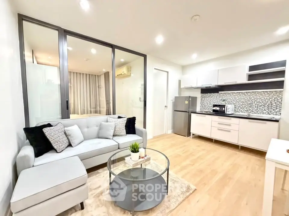 Modern open-layout living room with stylish kitchen and cozy seating area, perfect for urban living.