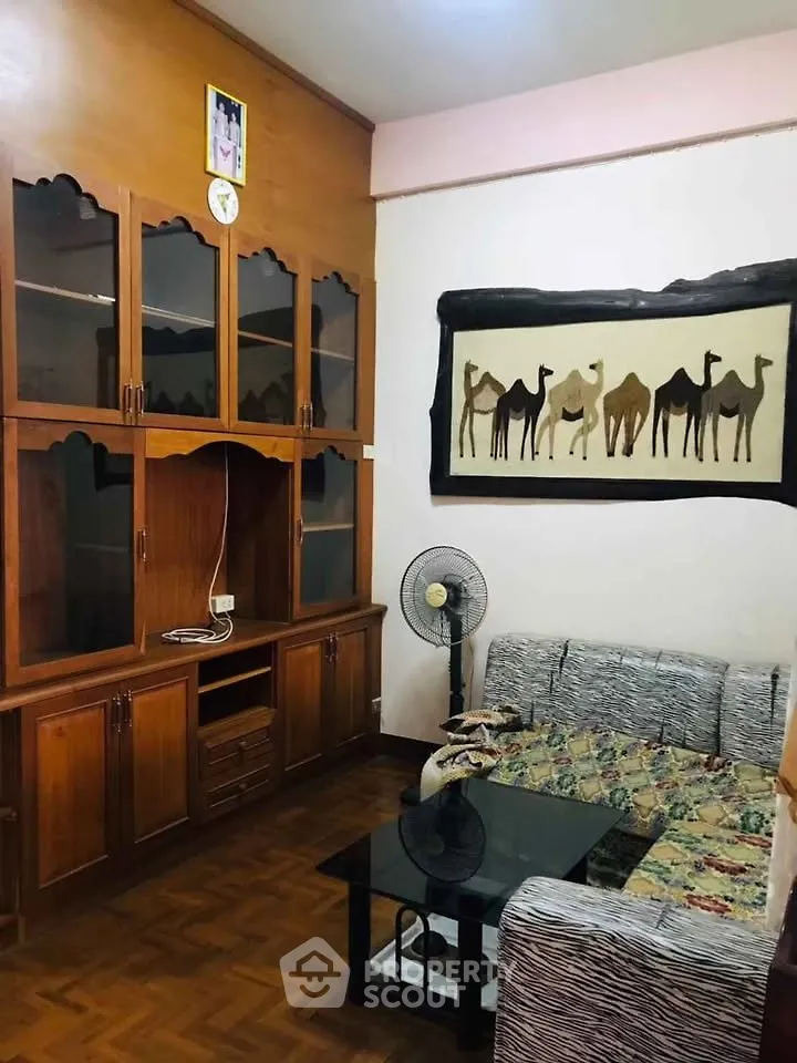 Cozy living room with wooden cabinets and camel wall art