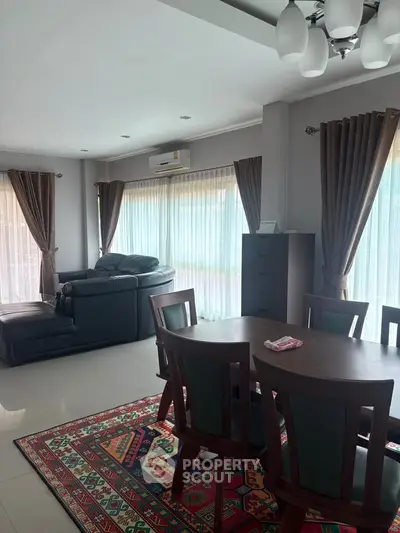 Spacious living room with elegant dining area and large windows for natural light.