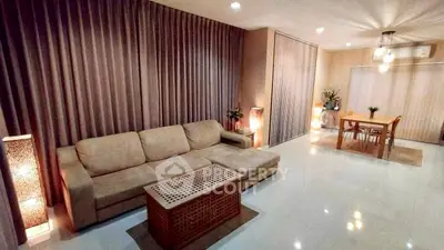 Spacious living room with elegant decor and dining area, featuring cozy lighting and modern furniture.