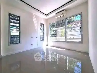 Bright and airy room with large windows and glossy floors, perfect for modern living.