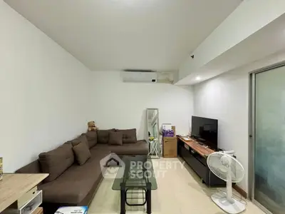 Cozy living room with modern brown sofa, glass coffee table, and flat-screen TV, perfect for relaxation.