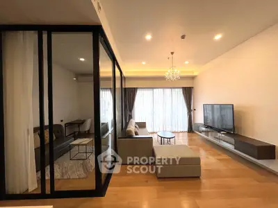 Spacious modern living room with elegant chandelier and large windows.