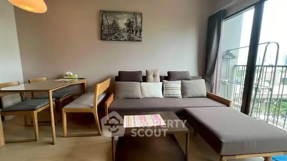 Modern living room with stylish furniture and large window offering city views.