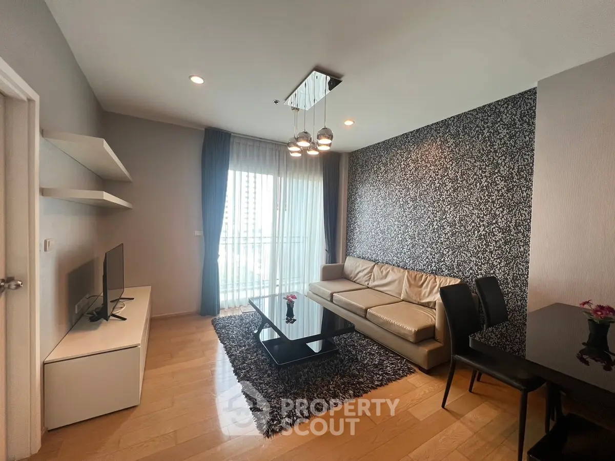 Modern living room with stylish decor, featuring a leather sofa, chic wallpaper, and a sleek TV setup.