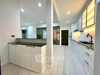 Modern kitchen with sleek cabinetry and open layout, featuring ambient lighting and spacious design.