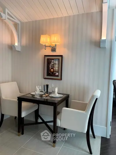 Elegant dining nook with stylish chairs and wall lighting
