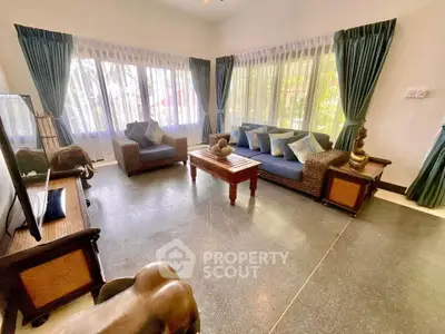 Spacious living room with elegant decor and large windows offering natural light.