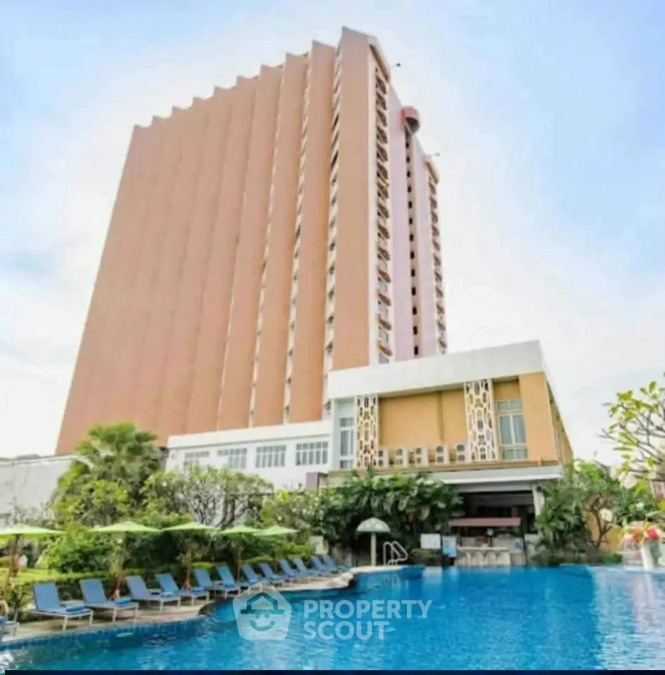 Luxurious high-rise building with stunning poolside view and lush greenery.