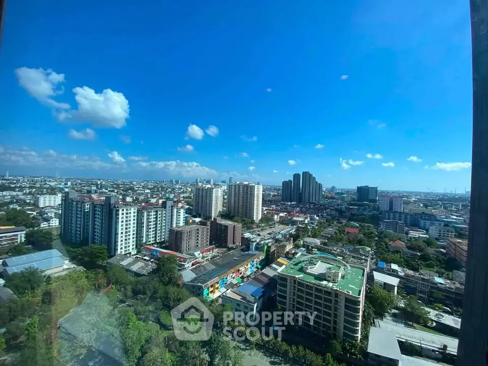 Stunning cityscape view from high-rise building showcasing urban skyline and clear blue sky.