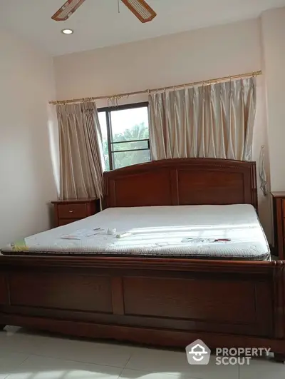 Cozy bedroom with wooden bed frame and natural light through window