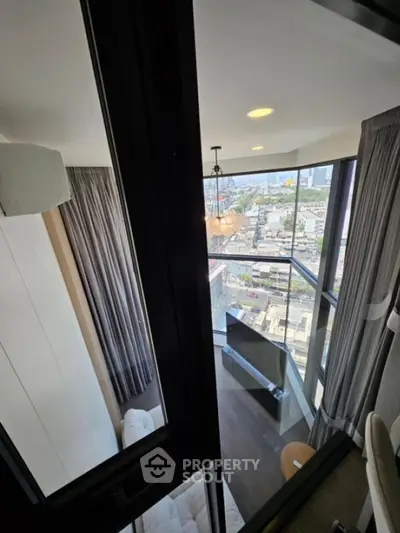 Modern high-rise apartment with stunning city view and cozy living area.