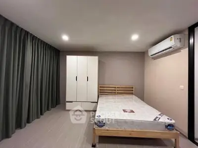 Spacious bedroom with modern design, featuring a comfortable bed and ample storage space.