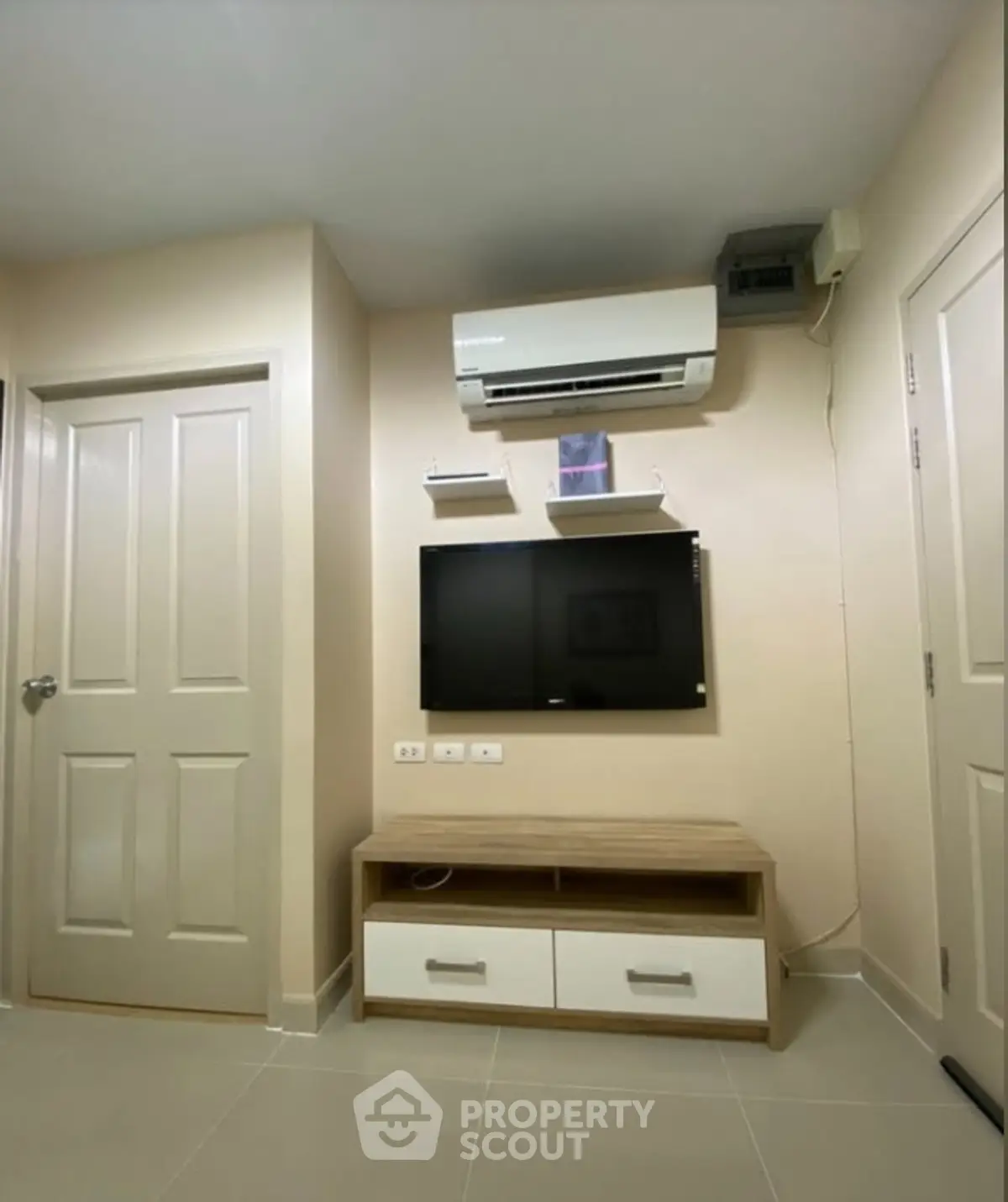 Modern living room with air conditioning and mounted TV in cozy apartment.