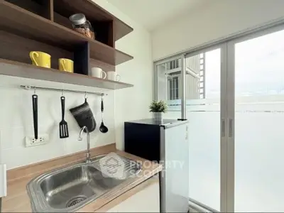 Modern kitchen with sleek design, featuring open shelving and compact refrigerator.