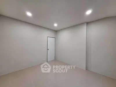 Minimalist empty room with tiled floor and recessed lighting, perfect for customization.