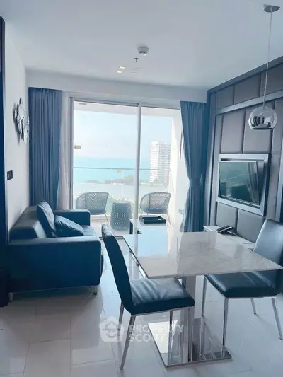 Modern living room with ocean view and stylish furniture in a high-rise apartment.