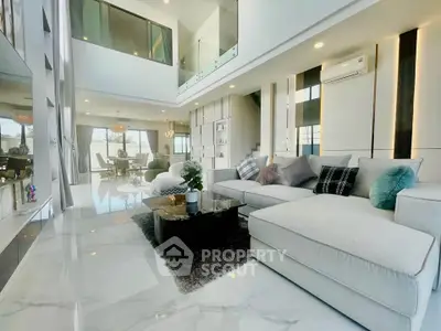 Luxurious modern living room with high ceilings and elegant decor in a spacious open-plan layout.