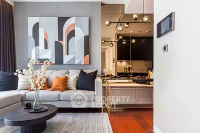 Modern living room with stylish decor and open kitchen layout, featuring elegant lighting and contemporary artwork.