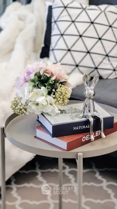 Stylish living room decor with modern table, books, and floral arrangement for a cozy ambiance.