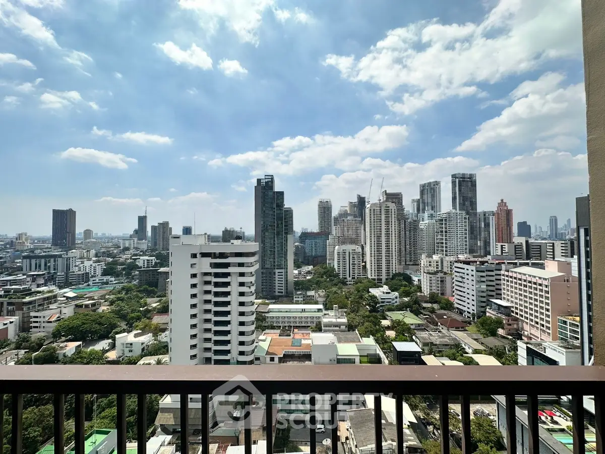 Stunning cityscape view from a high-rise balcony showcasing urban skyline and blue skies.