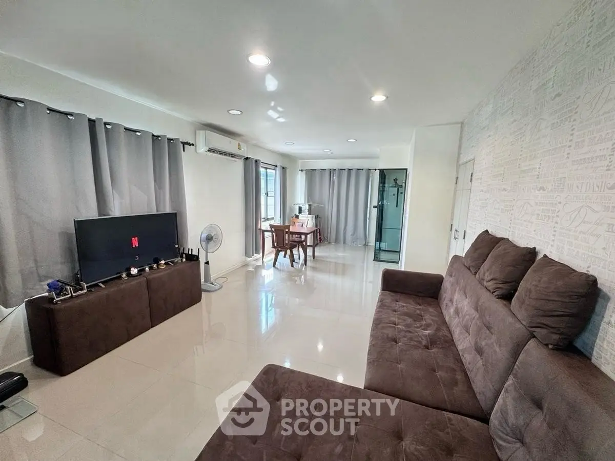 Spacious living room with modern decor and large sofa, perfect for relaxation.