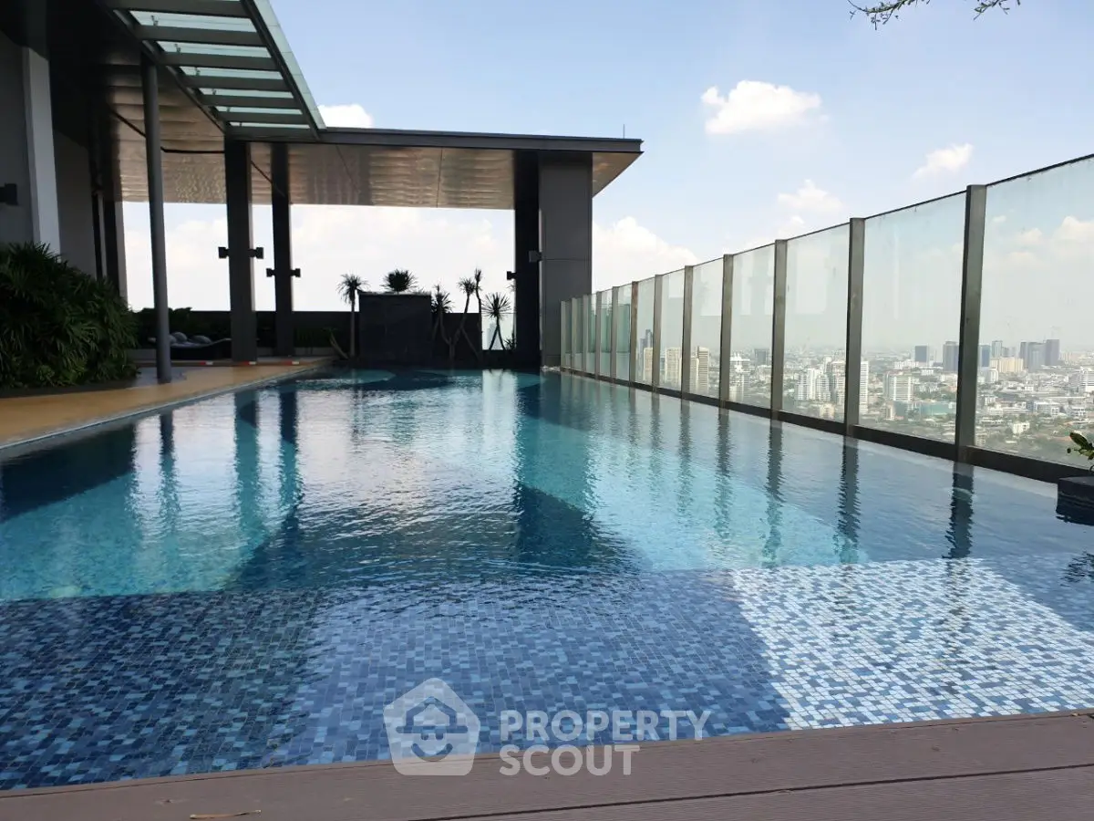 Luxurious rooftop pool with stunning city skyline view, perfect for relaxation and leisure.