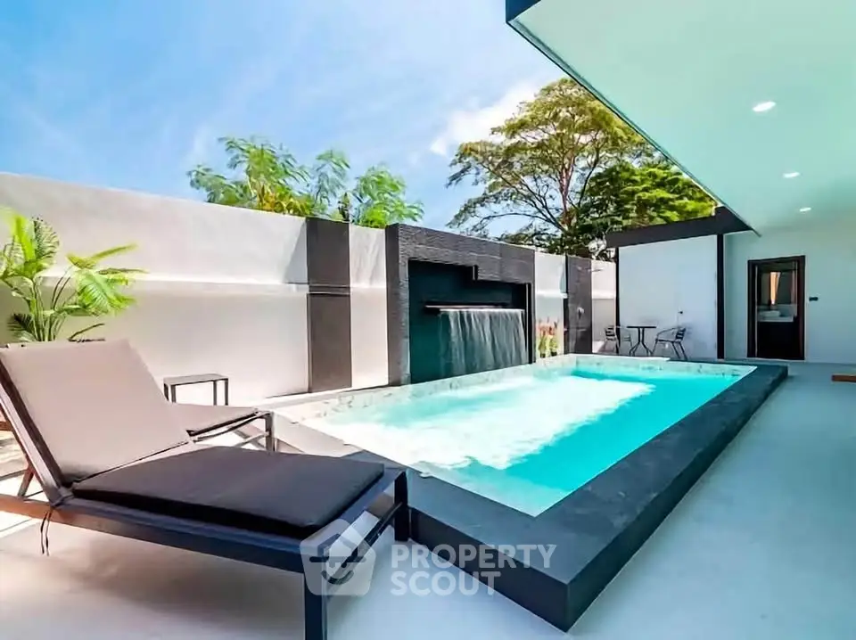 Luxurious modern villa with private pool and sun loungers, perfect for relaxation.