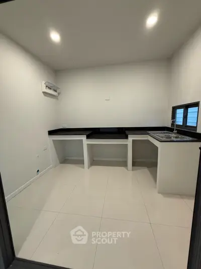 Modern minimalist kitchen with sleek countertops and ample space.