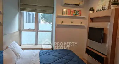 Cozy bedroom with modern decor and large window for natural light.