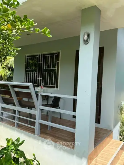 Charming outdoor patio with seating area and lush greenery, perfect for relaxation and entertaining.