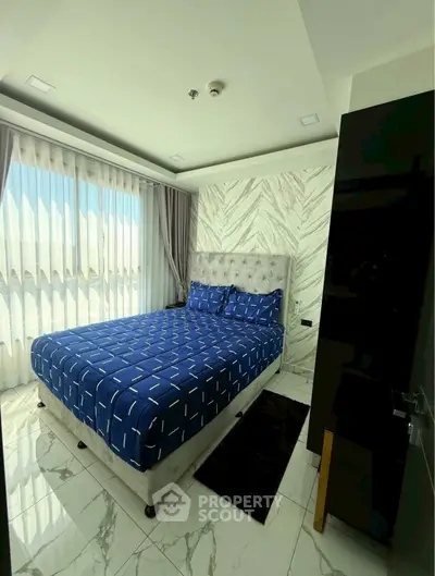 Modern bedroom with stylish decor and large windows offering natural light.