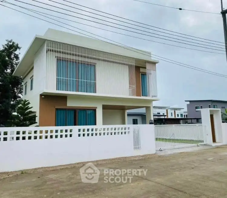 Modern two-story house with sleek design and spacious driveway in a serene neighborhood.