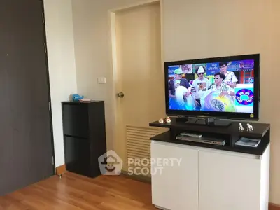 Modern living room with wooden flooring and TV entertainment unit.