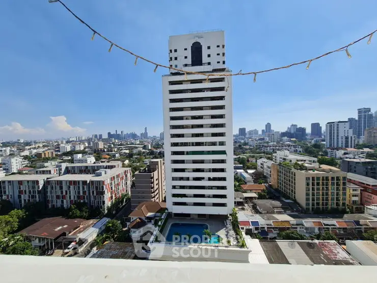 Stunning cityscape view featuring a modern high-rise building with a rooftop pool, perfect for urban living.