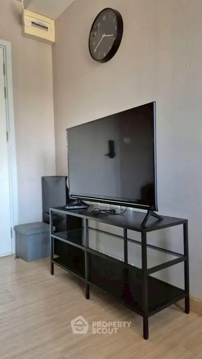 Modern living room with sleek TV stand and wall clock, perfect for cozy entertainment.