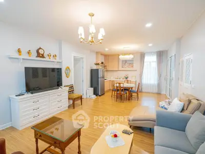 Spacious living room with elegant decor and open kitchen layout, featuring modern appliances and cozy seating area.
